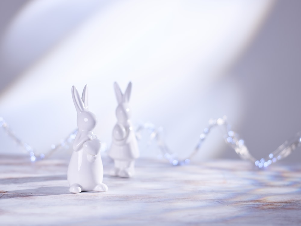 a couple of white rabbits sitting on top of a table