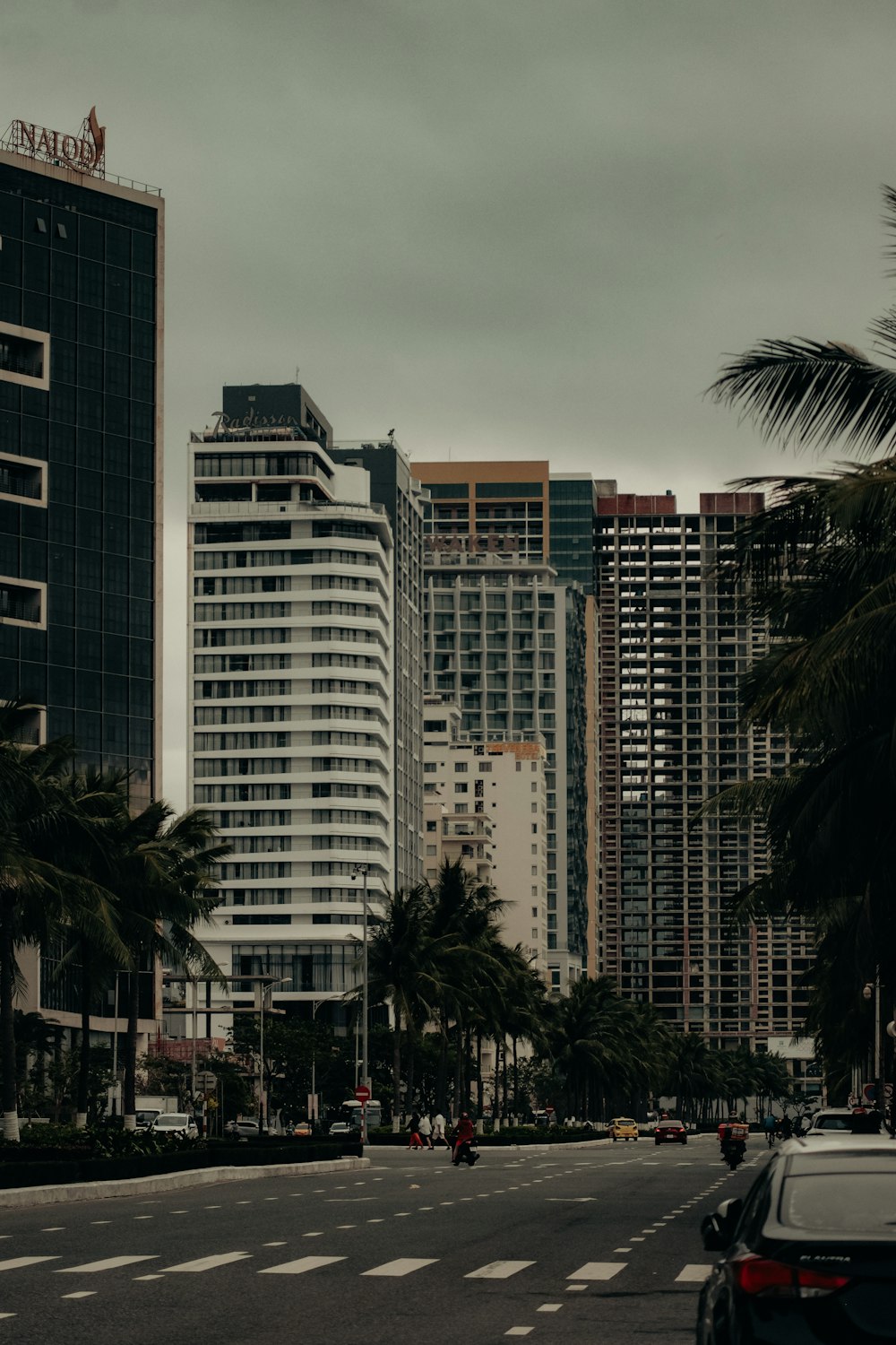 a city street lined with tall buildings and palm trees