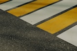 a yellow and white cross walk on asphalt