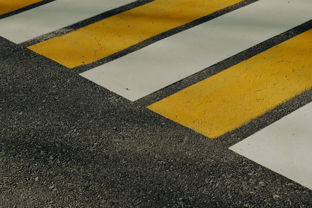 a yellow and white cross walk on asphalt