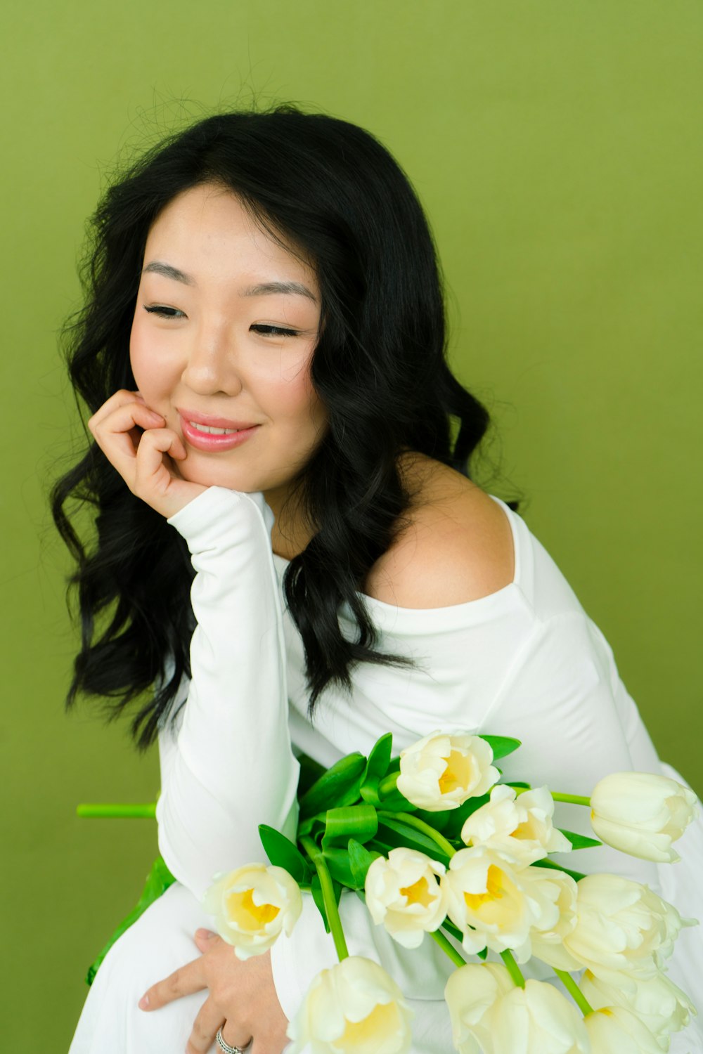 a woman in a white dress holding a bouquet of flowers