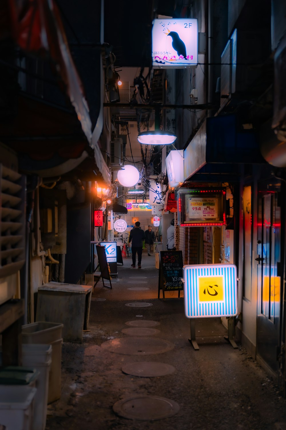 a narrow alley way with a sign on the side of it