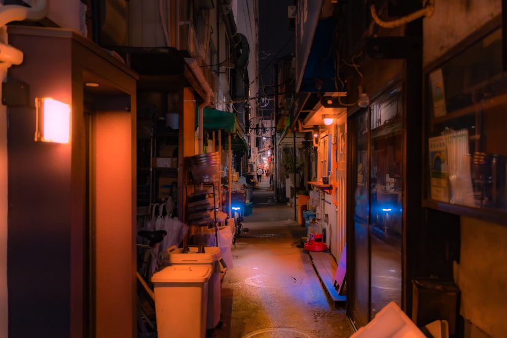 a narrow alley way with a light on at the end