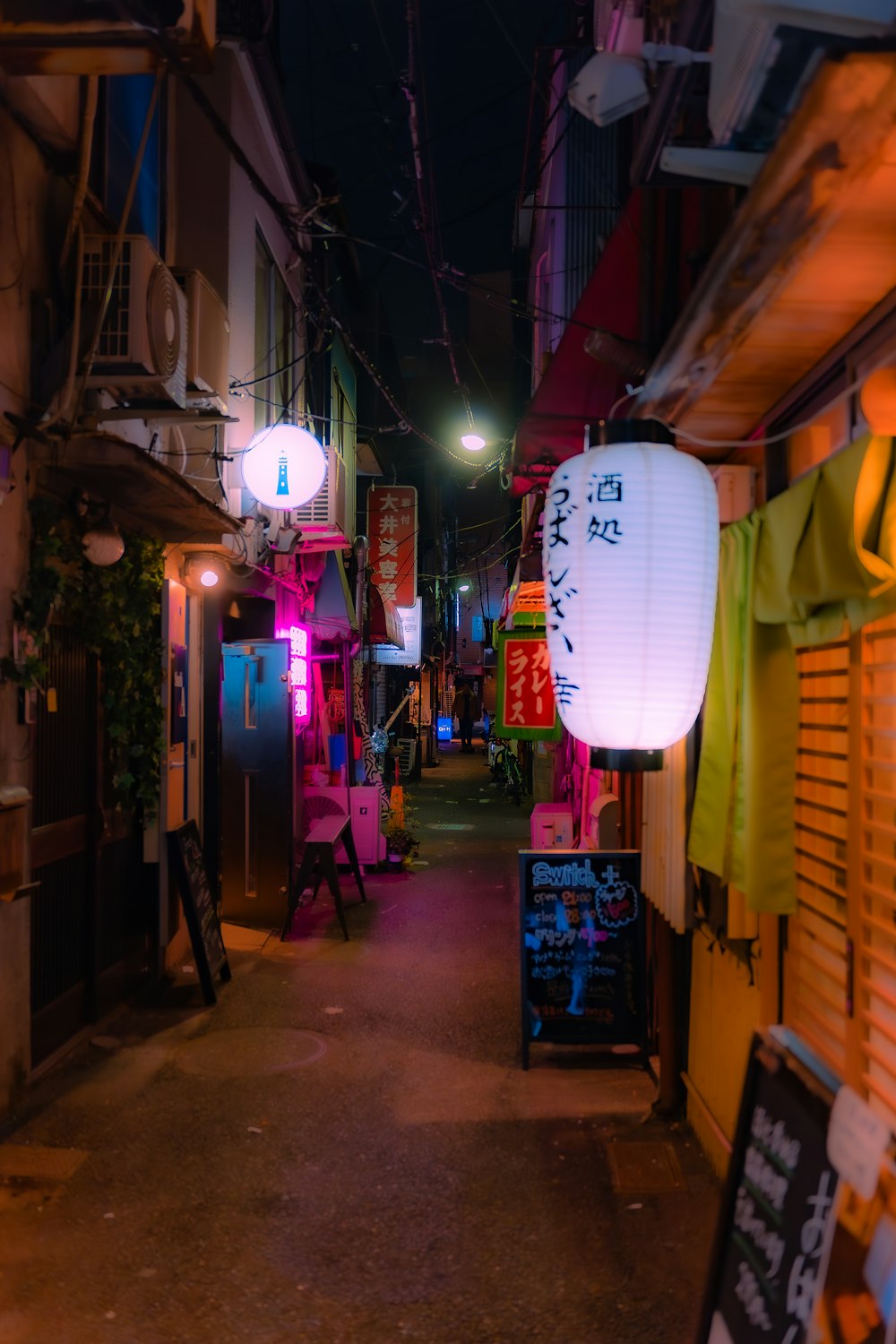 a narrow alley way with a lantern hanging from the ceiling