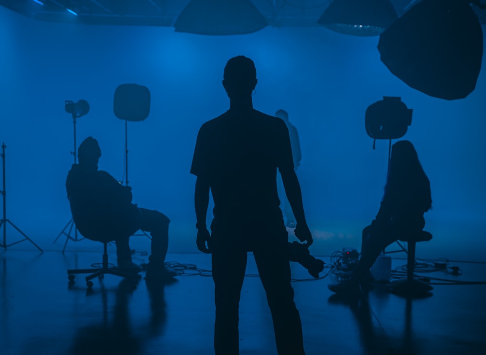 a man standing in front of a camera in a dark room