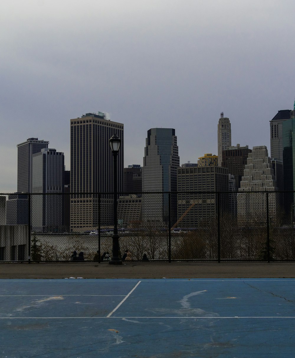 a tennis court with a city in the background