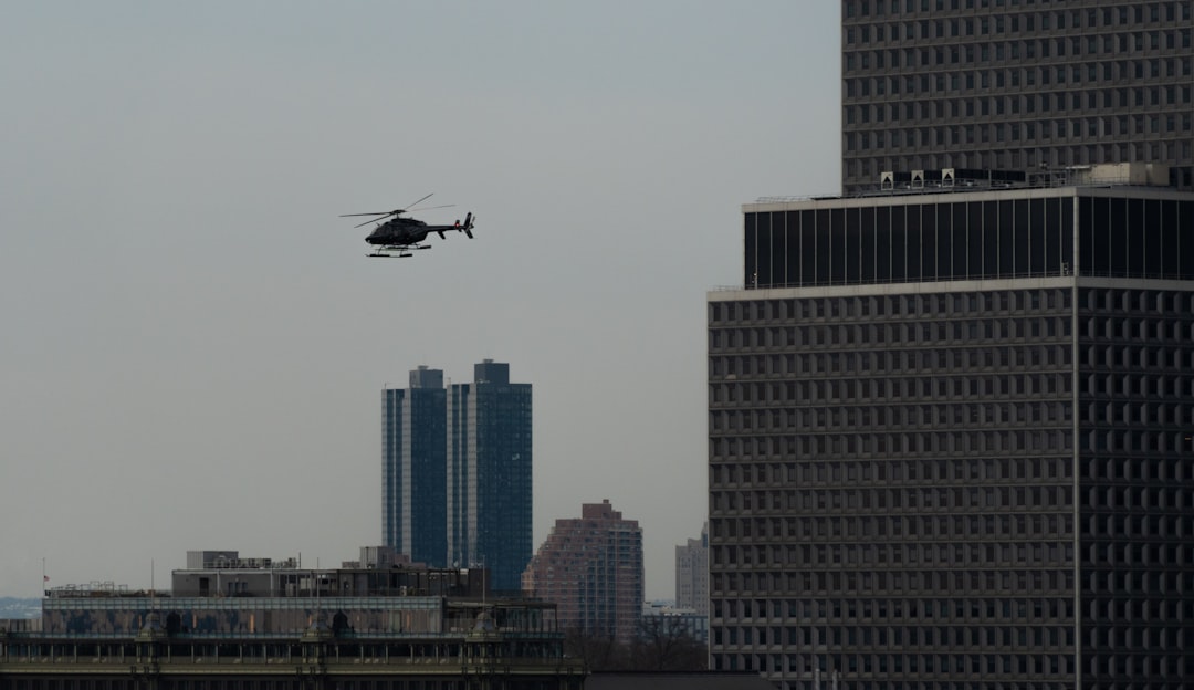 a helicopter flying over a city with tall buildings,