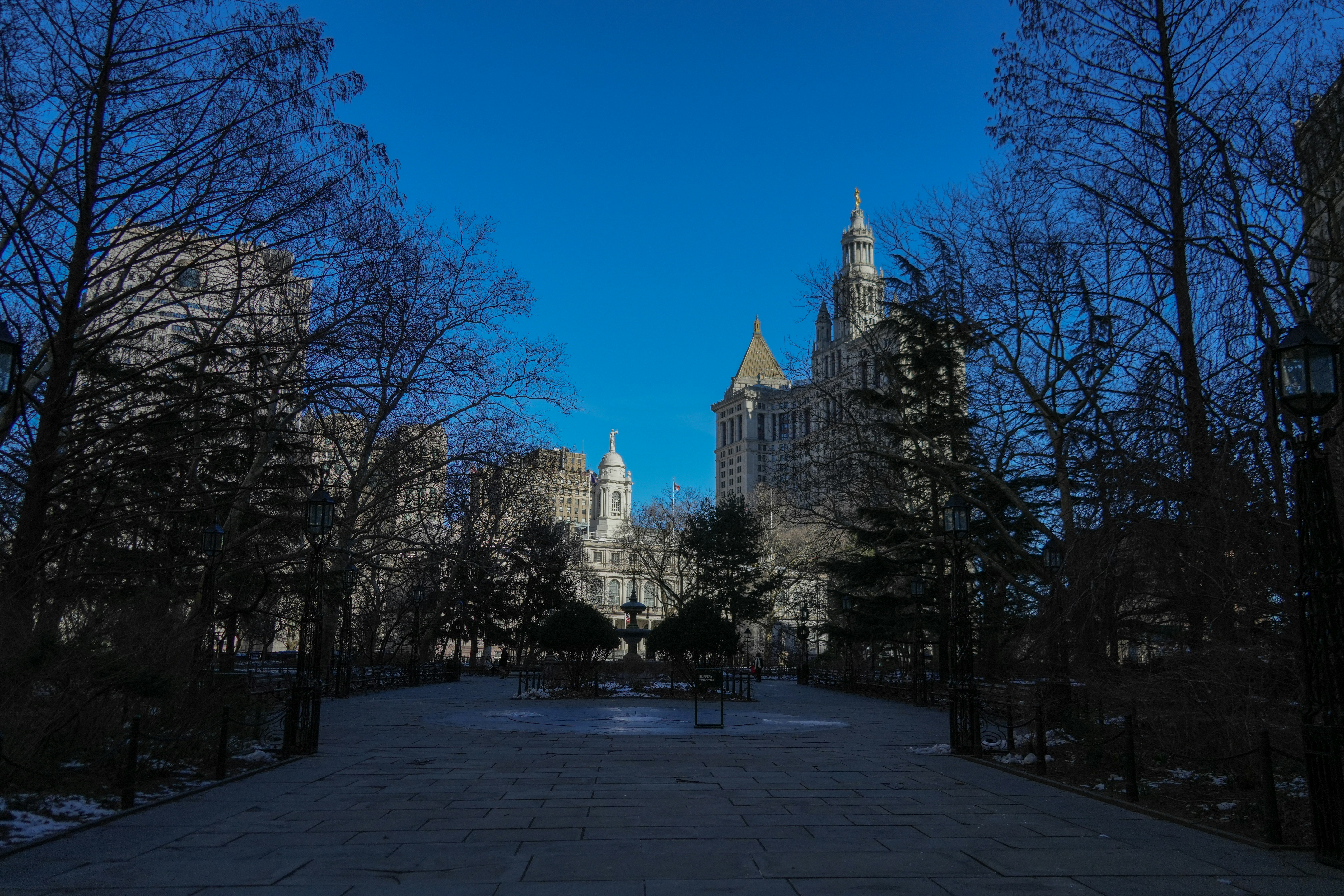 a large building with a clock tower in the middle of a park