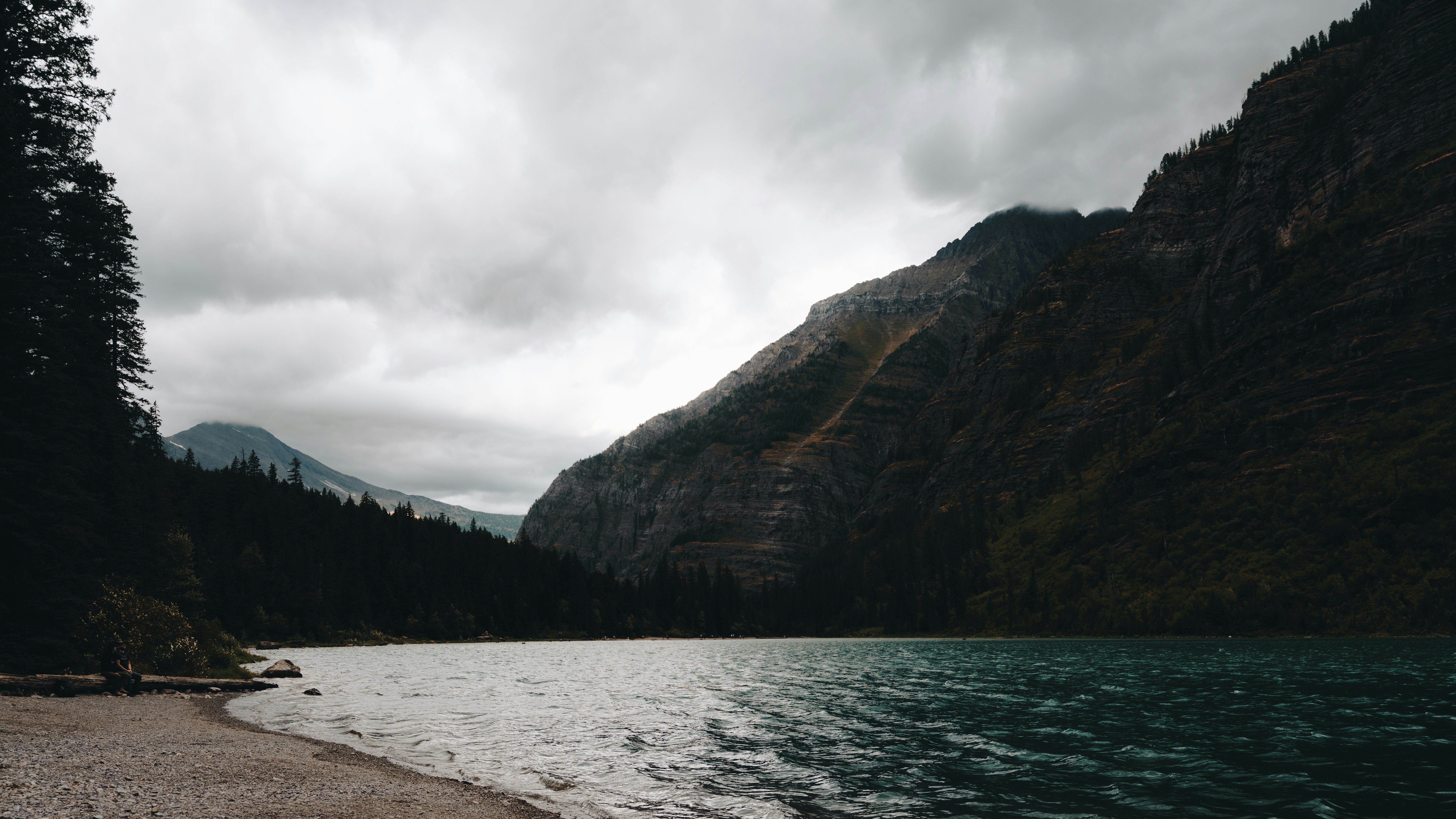 a body of water surrounded by mountains and trees, 