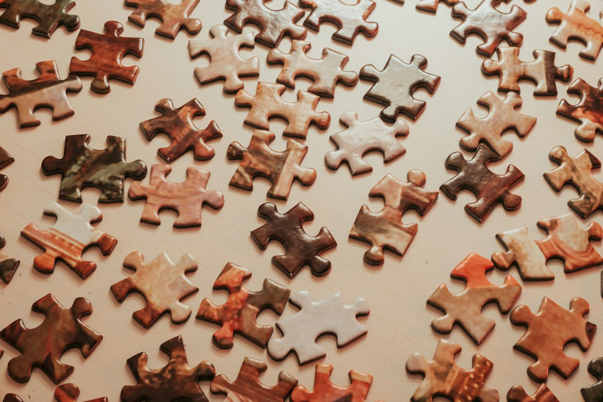Wooden jigsaw puzzle pieces scattered across a table
