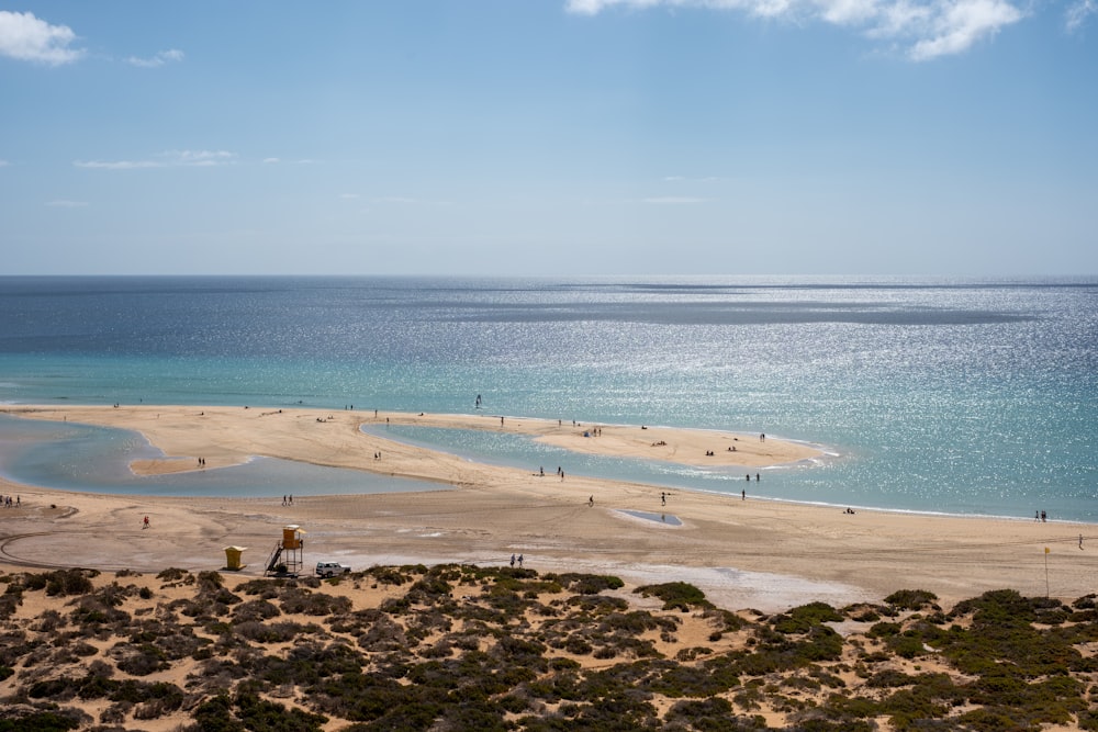 a view of a beach with people walking on it