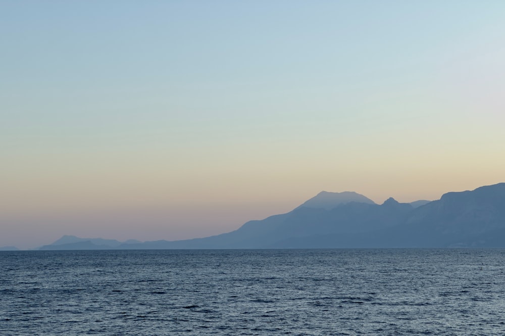 a large body of water with mountains in the background