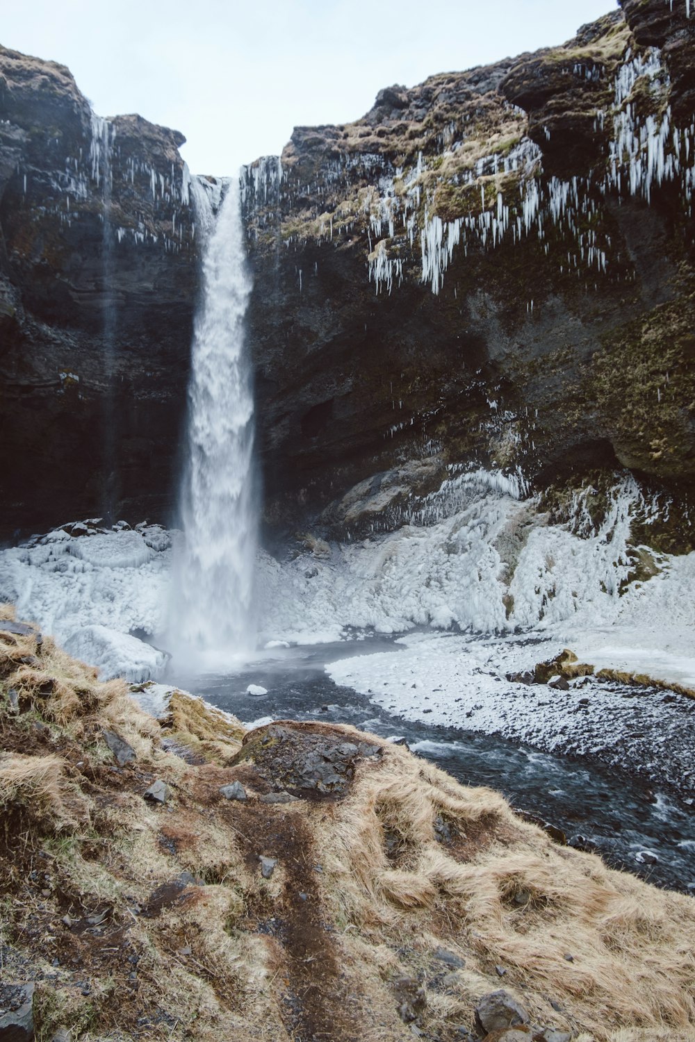 a waterfall with ice hanging off of it's sides