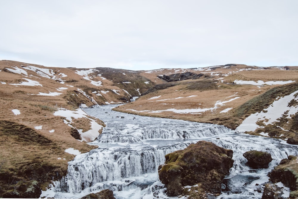 a small waterfall in the middle of a mountain