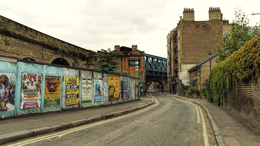 a street with a bunch of posters on the side of it