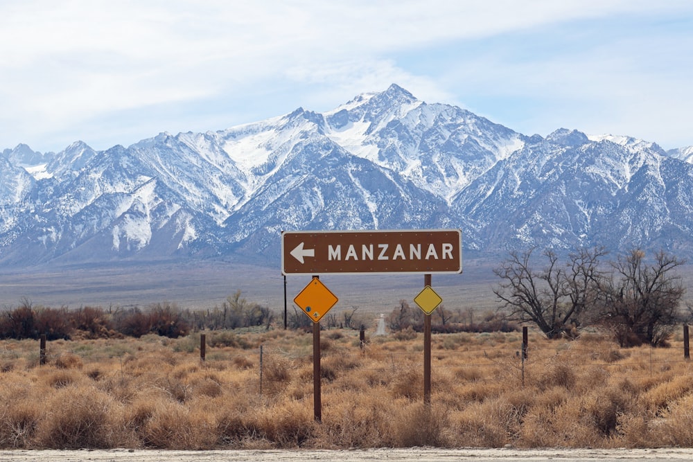 a road sign in front of a mountain range