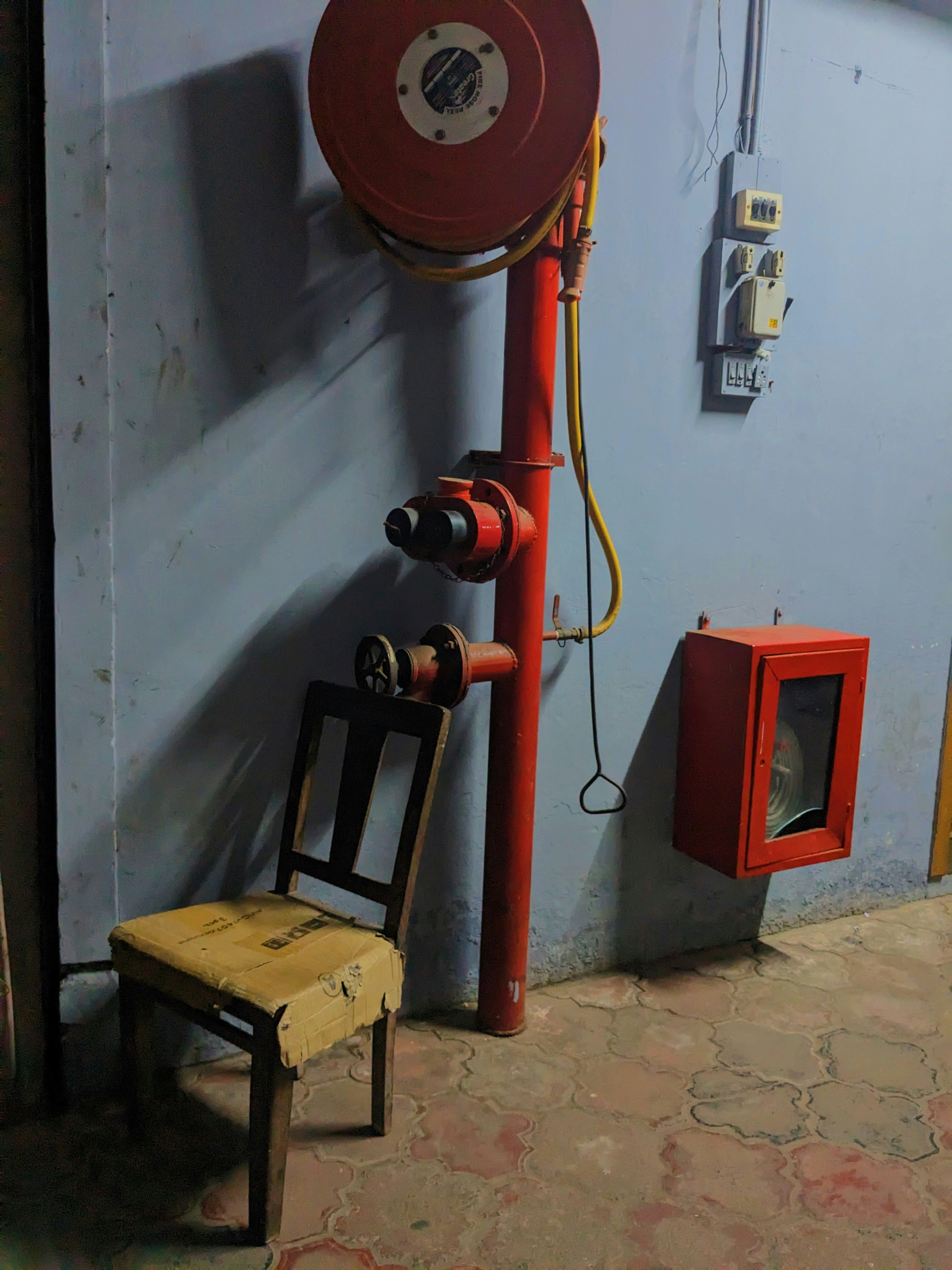 a room with a chair and a phone on the wall