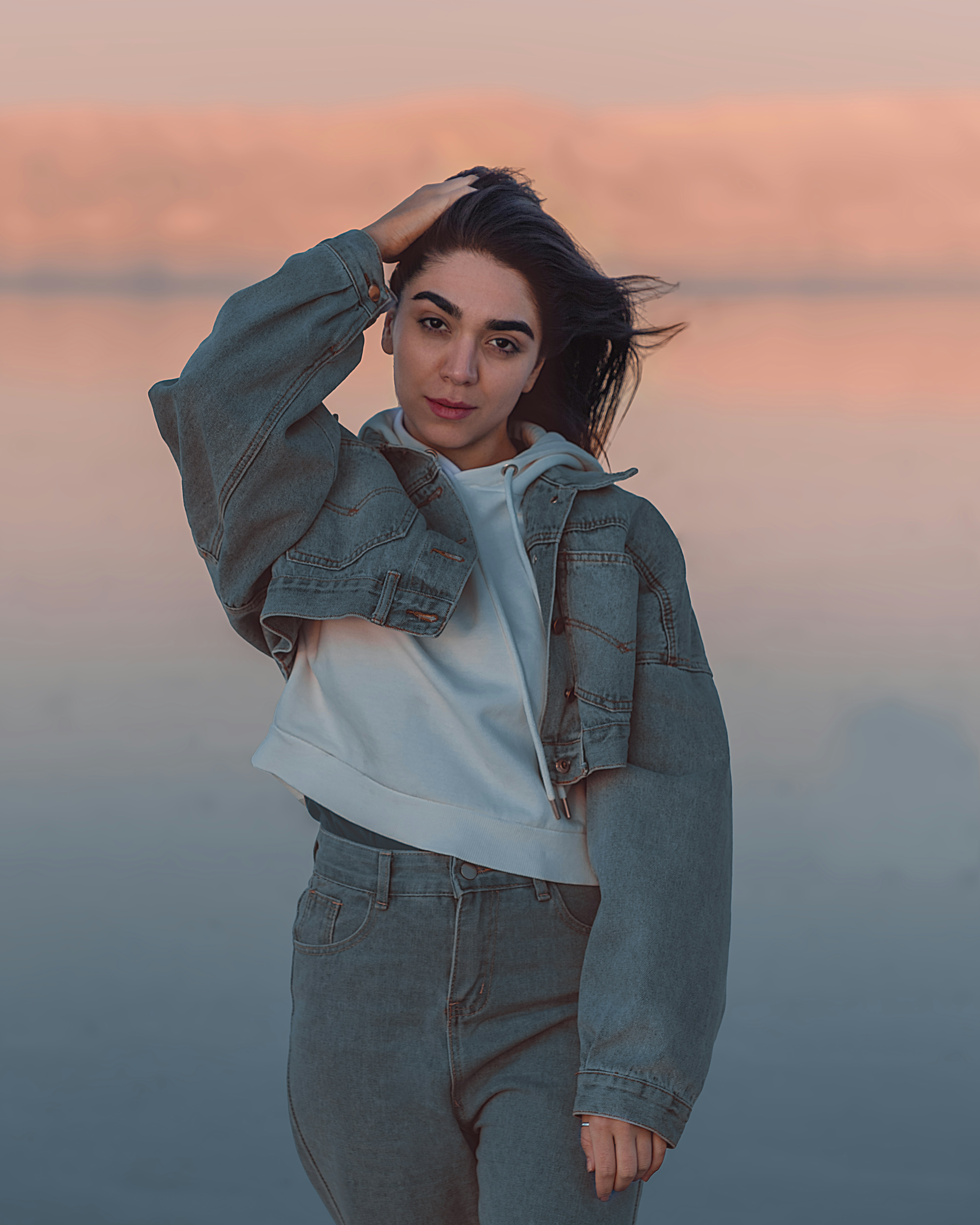 a woman standing in front of a body of water