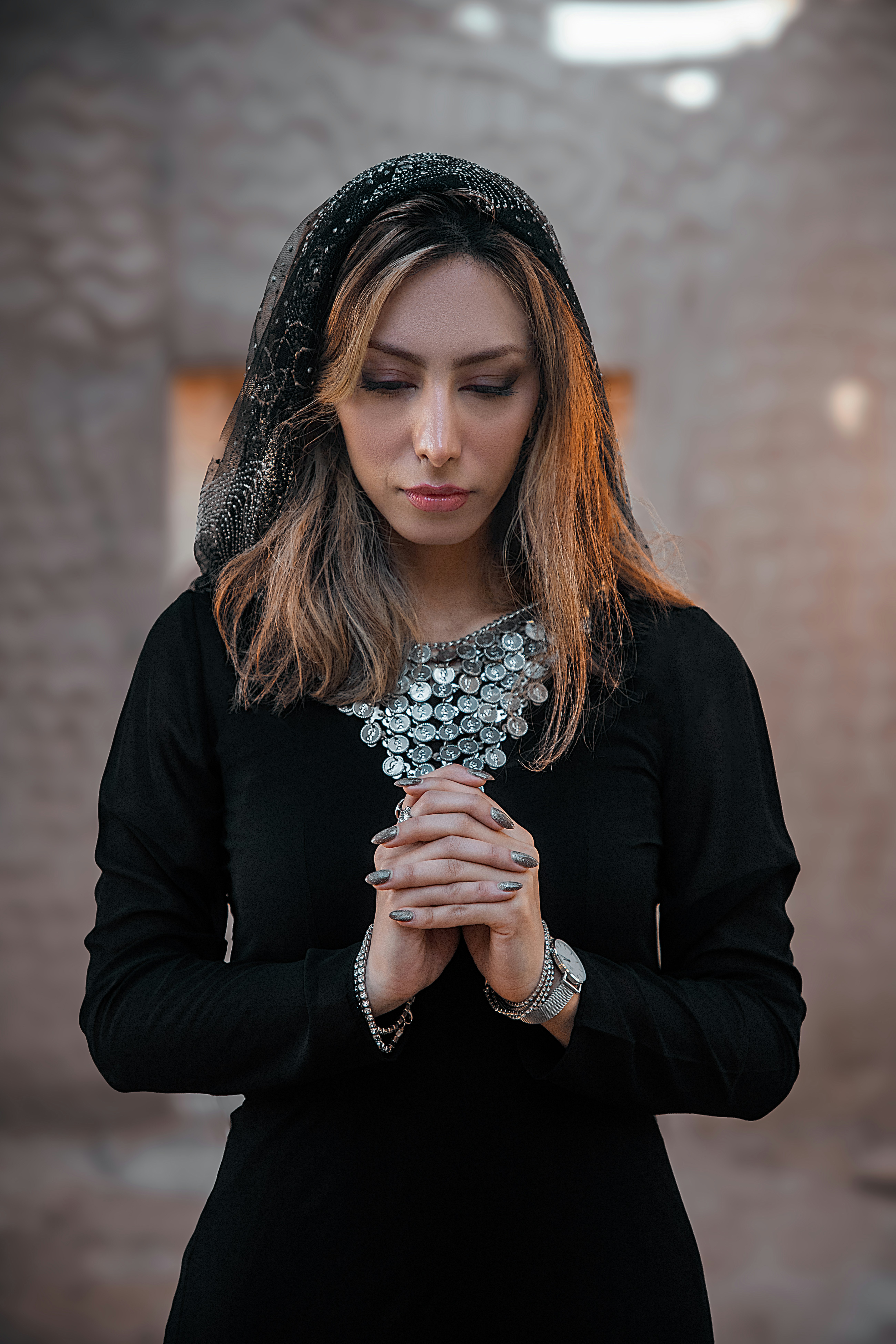 a woman in a black dress is holding her hands together