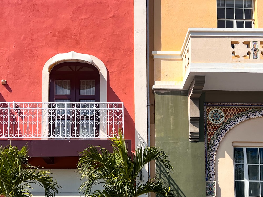 a red and yellow building with a white balcony