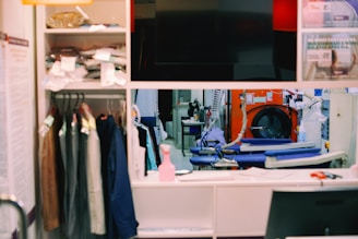 a room with a television, clothes and other items