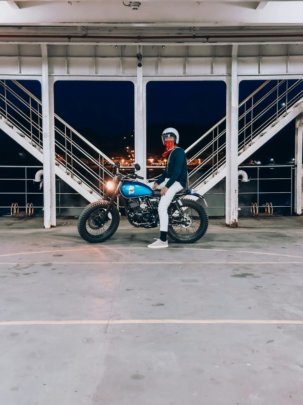 a man sitting on top of a blue motorcycle