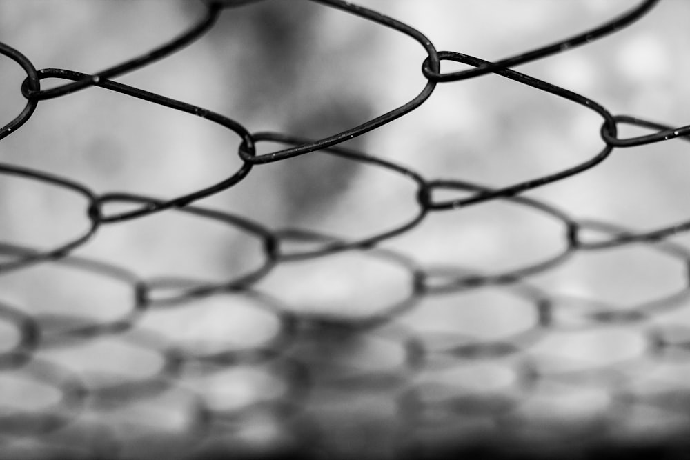a black and white photo of a chain link fence