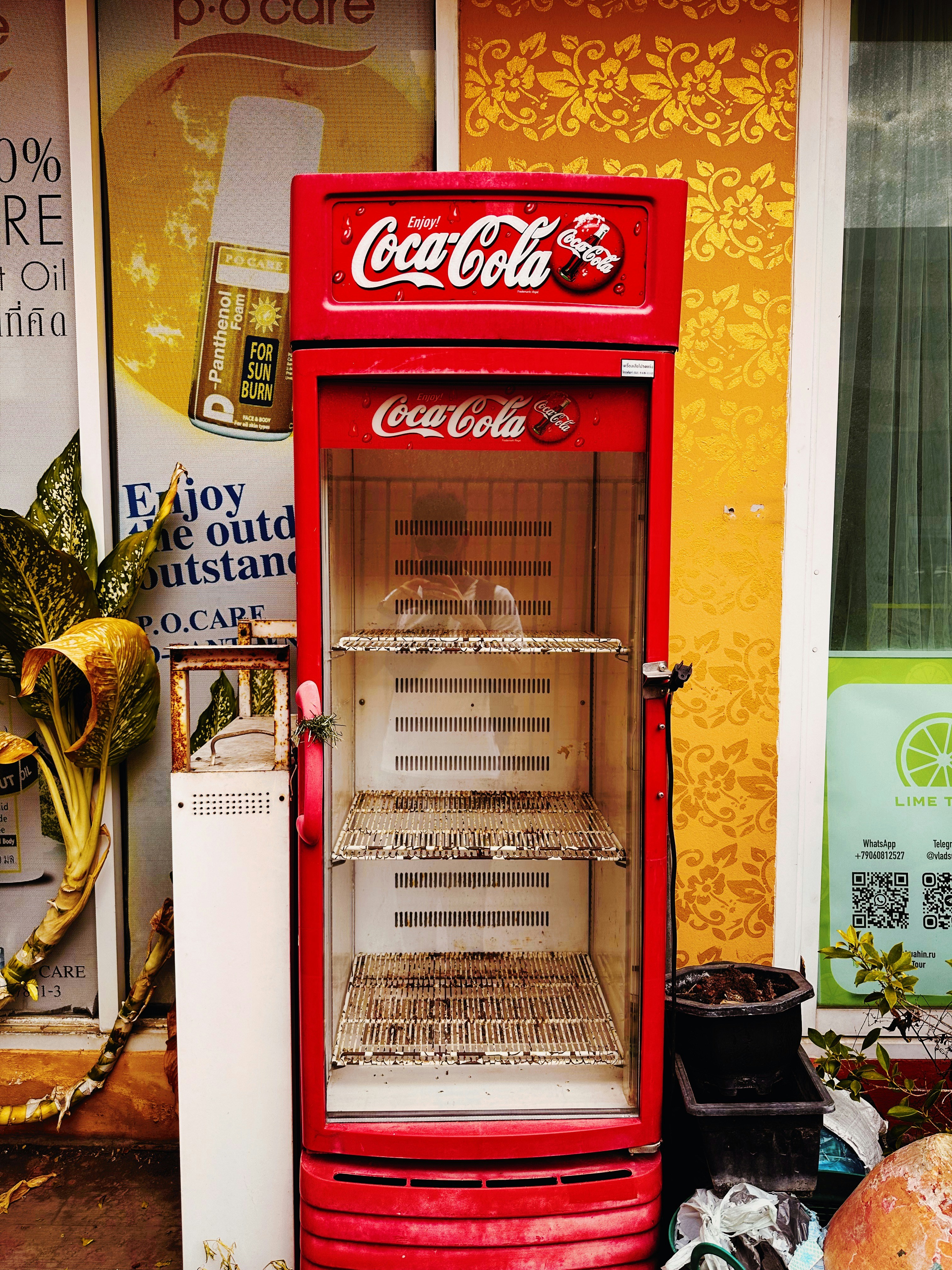 an old fashioned coca - cola vending machine sits in front of a store