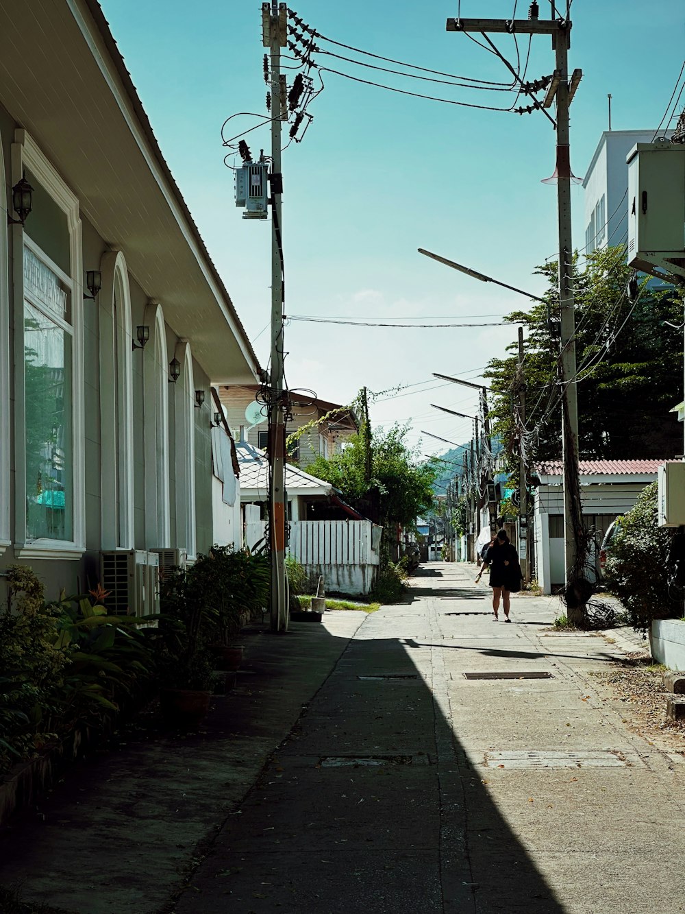 a person walking down a street next to a row of houses