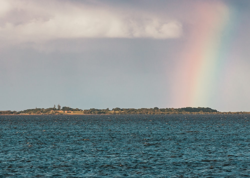 a rainbow in the sky over a body of water