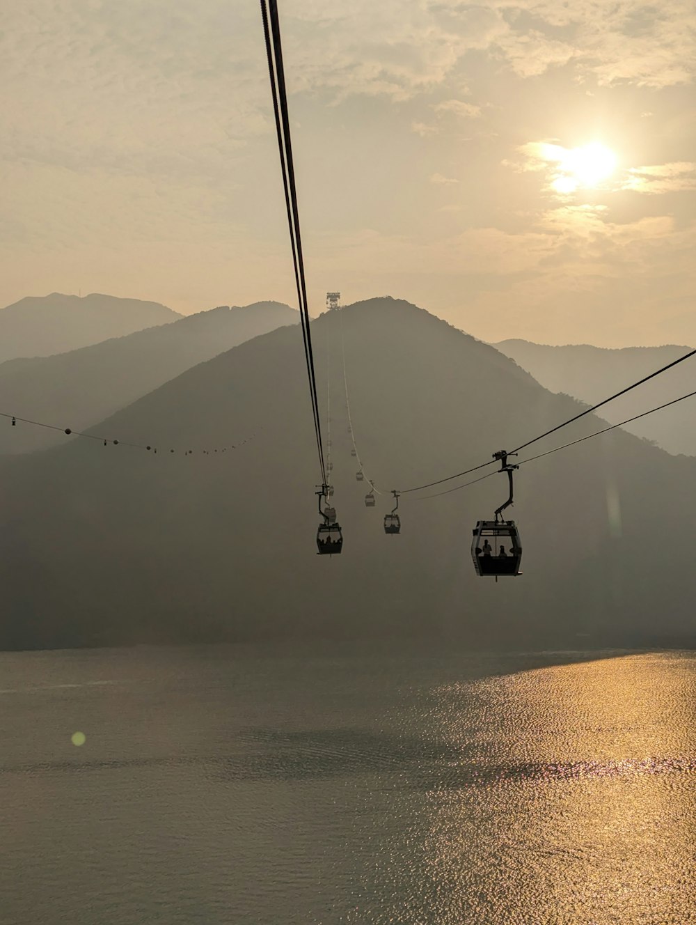 a couple of gondolas suspended over a body of water