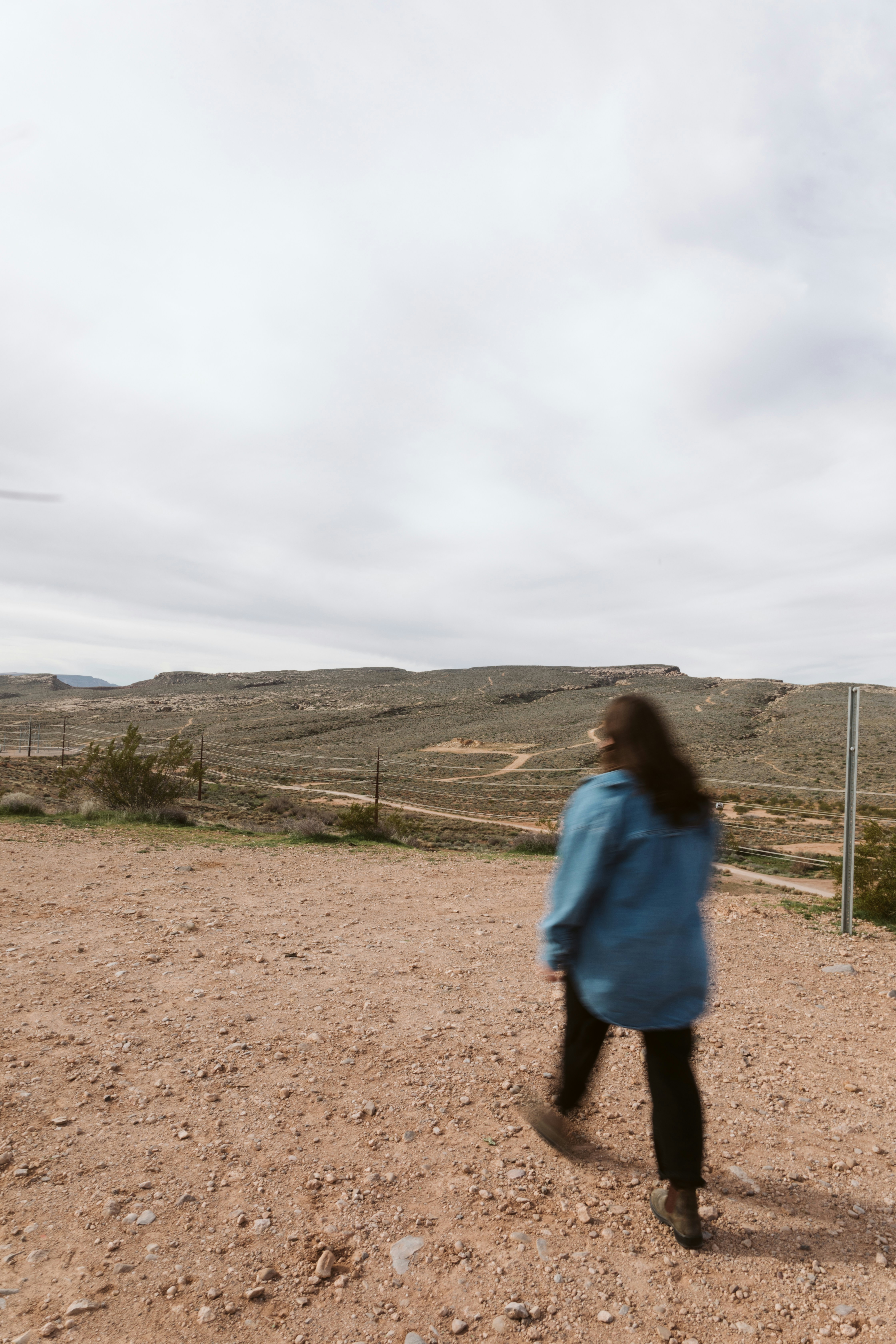 파란 재킷을 입은 여성이 연을 날리고 있습니다.