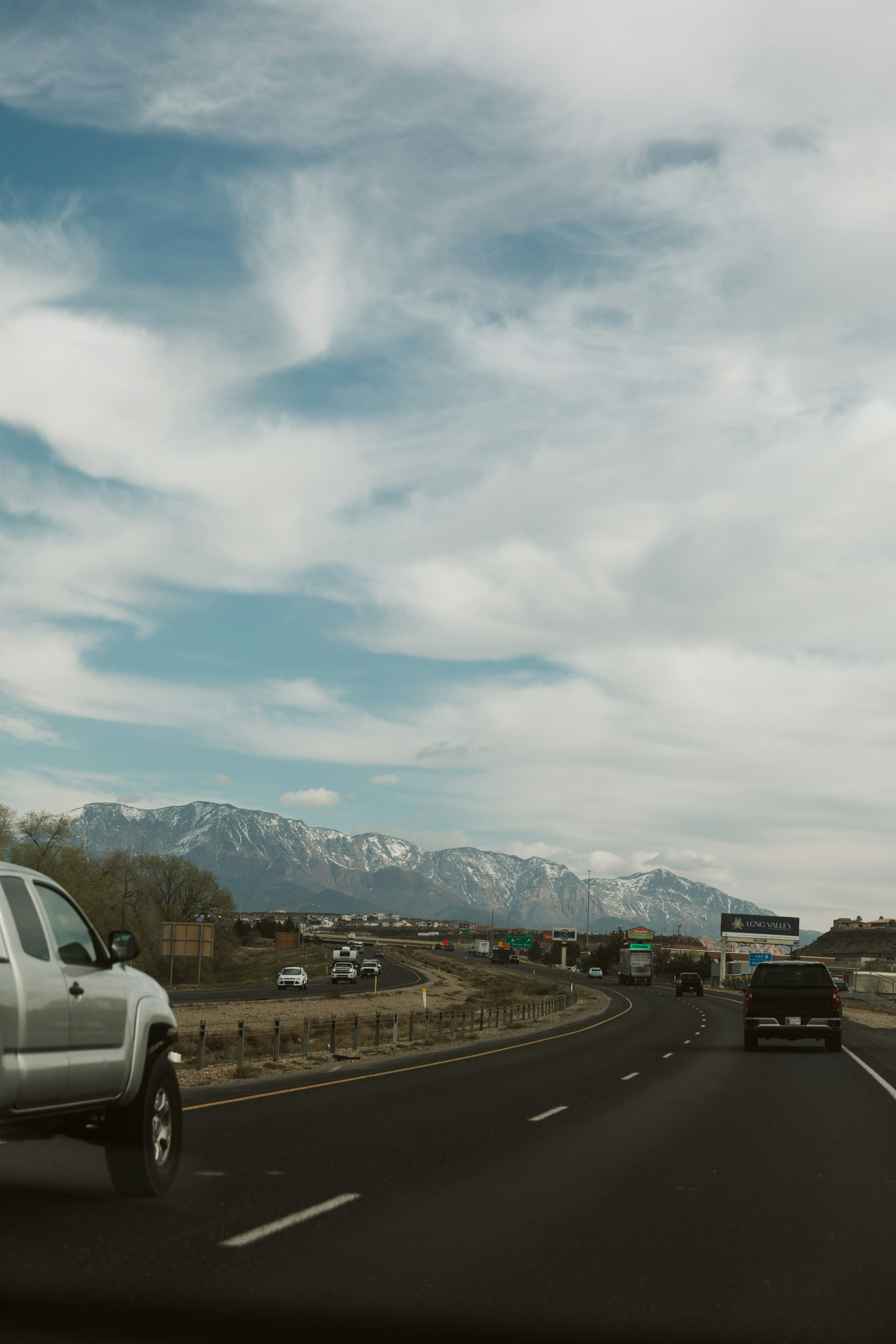 산을 배경으로 고속도로를 달리는 트럭