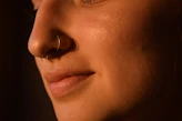 a close up of a woman with a nose piercing