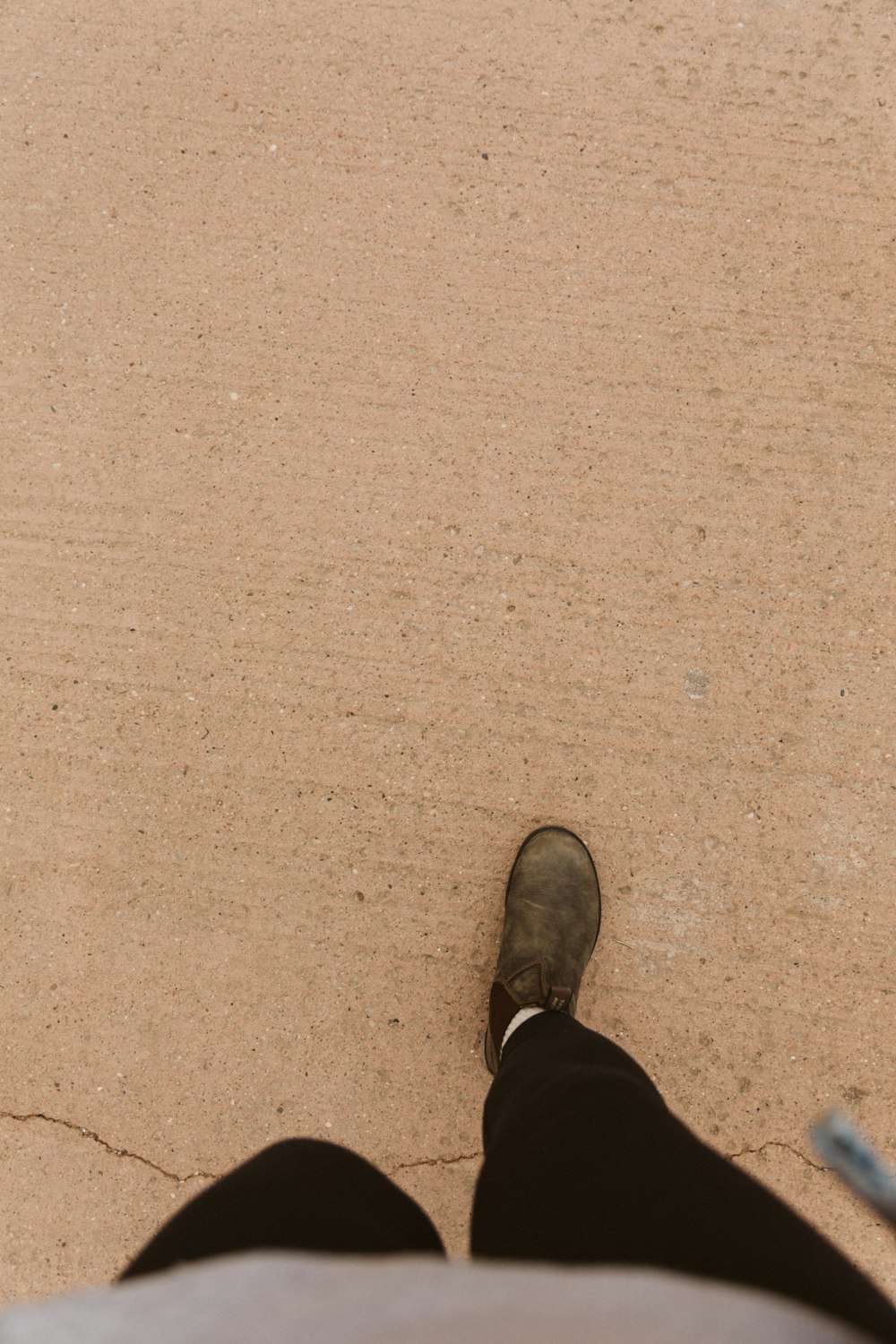 a person standing in the sand with their feet up