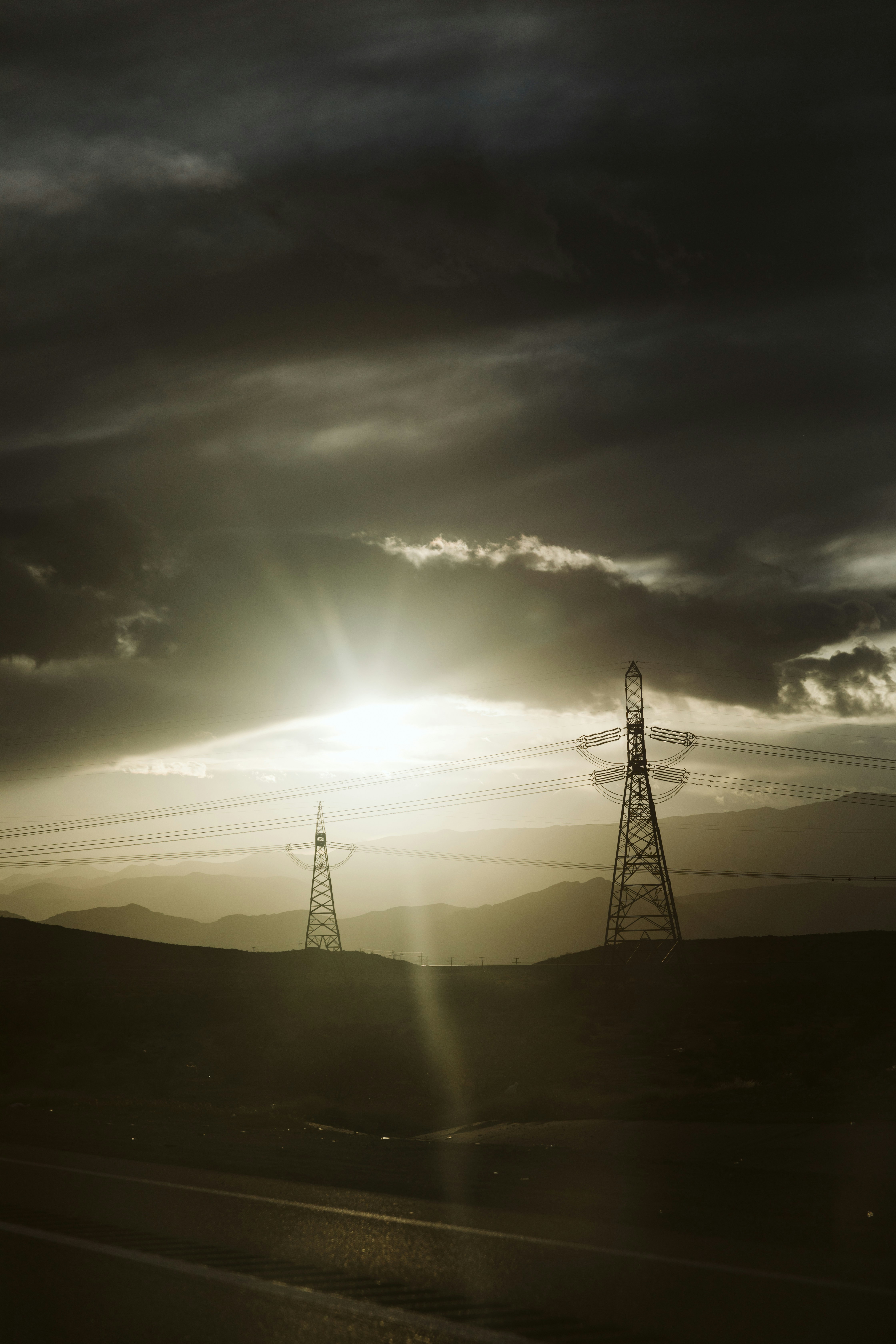 the sun is shining through the clouds over the hills