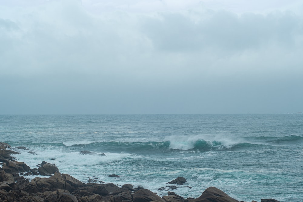 a large body of water sitting next to a rocky shore