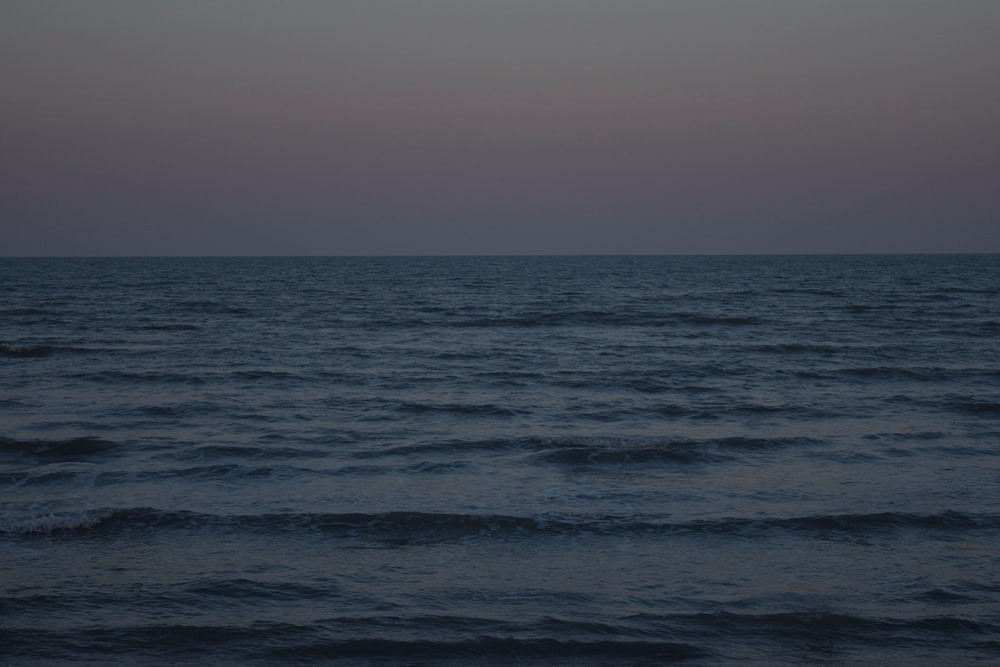 a large body of water with a sky in the background