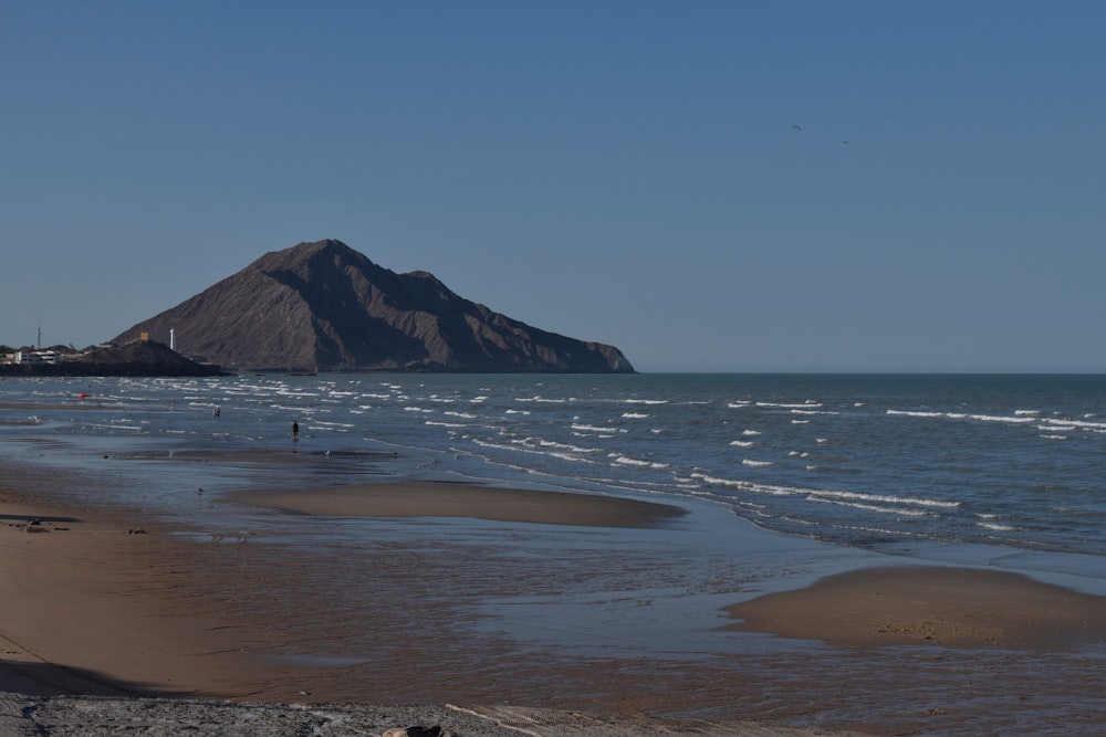 ein Strand mit einem Berg im Hintergrund