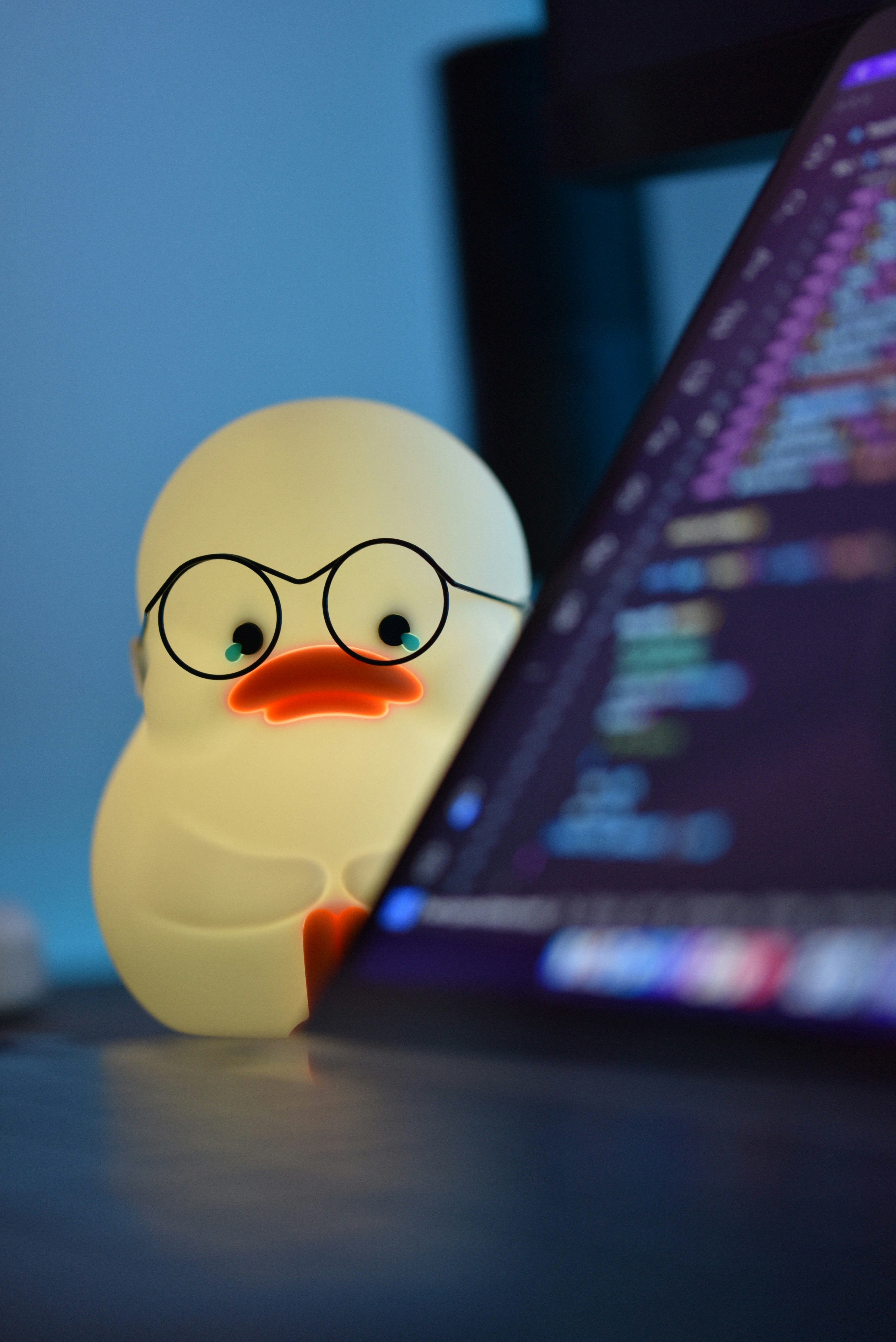 a rubber duck wearing glasses next to a computer