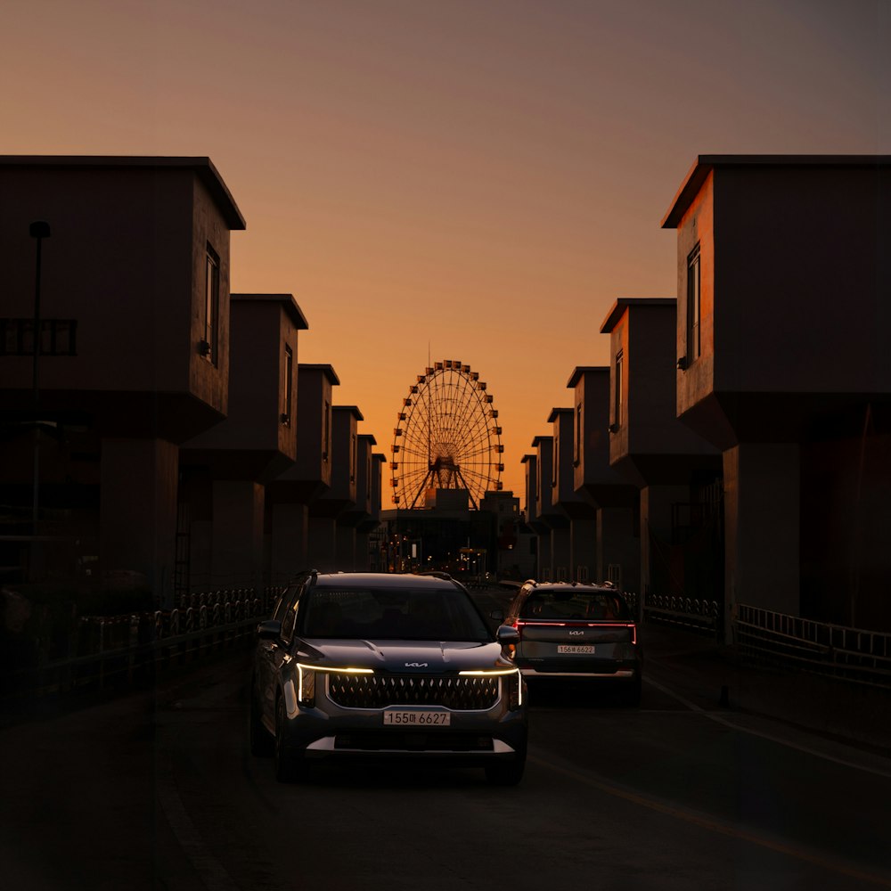 a car driving down a street next to a ferris wheel