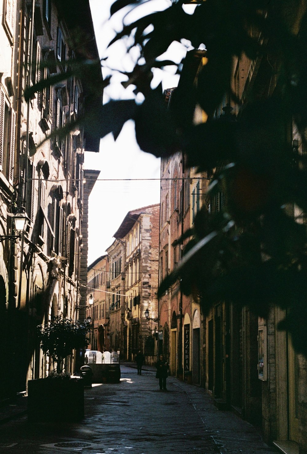 a narrow city street lined with tall buildings