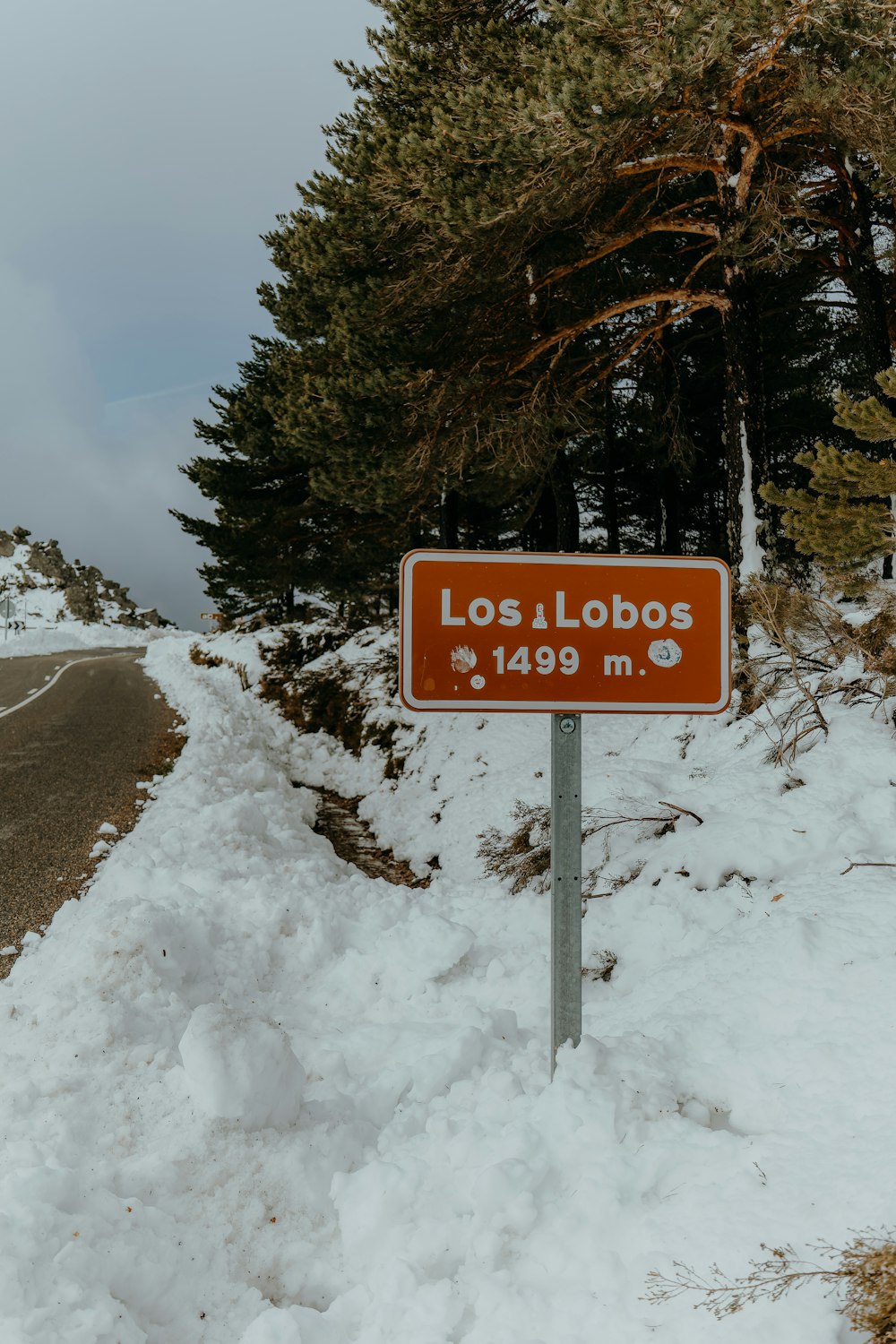 a sign on the side of a snowy road