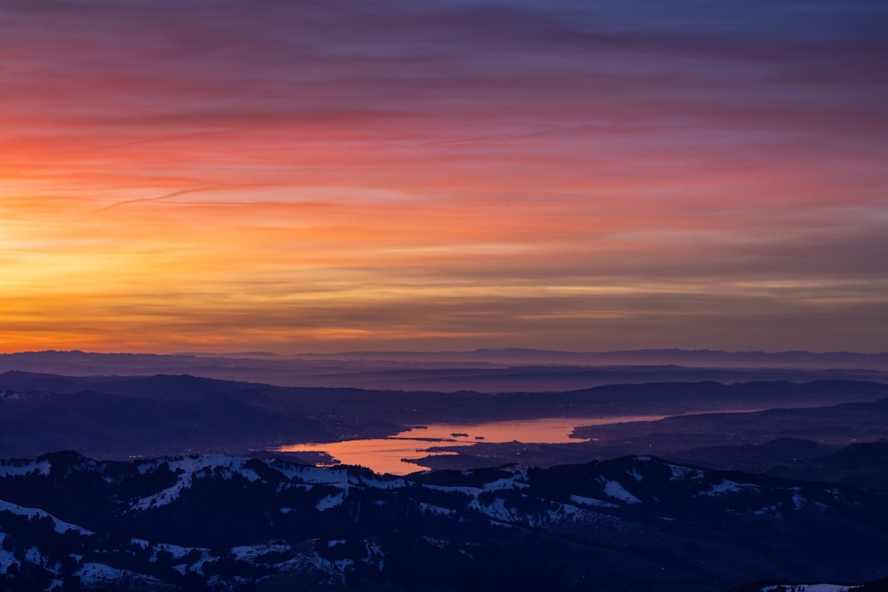 the sun is setting over a mountain range