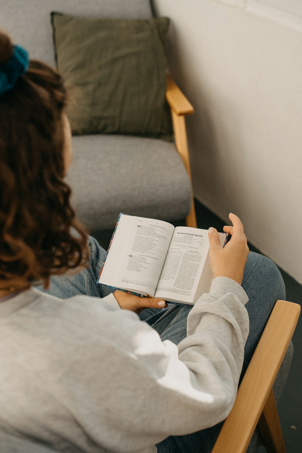 a woman sitting in a chair reading a book