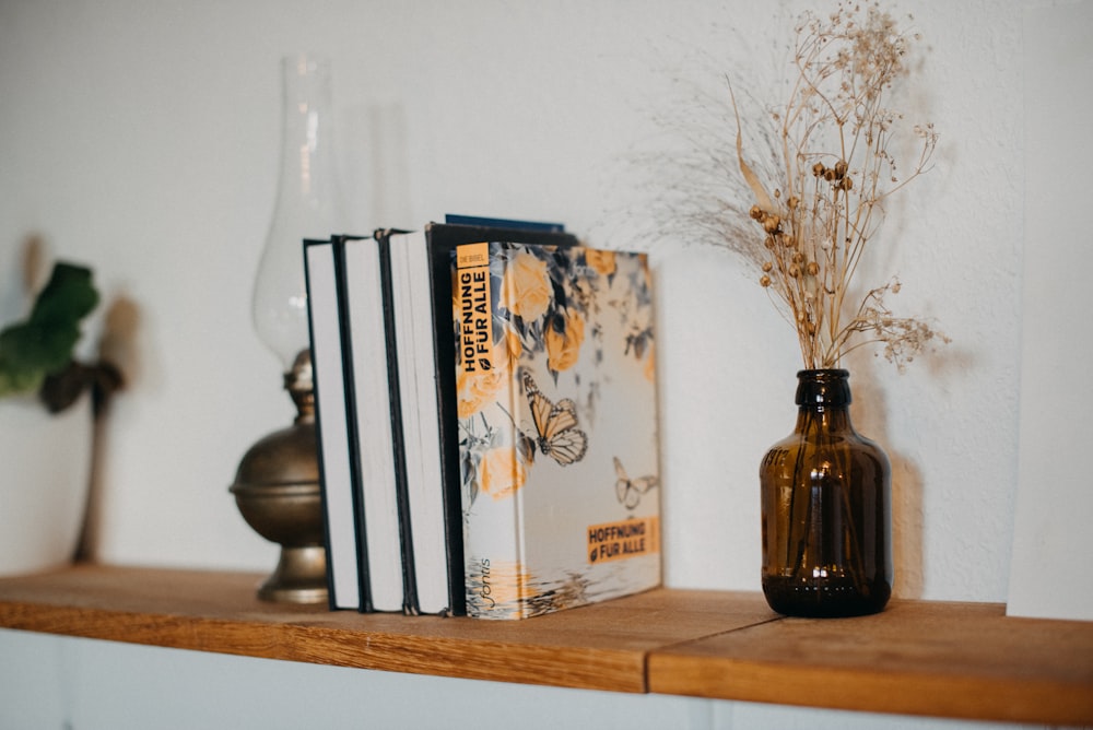 a couple of books sitting on top of a wooden shelf