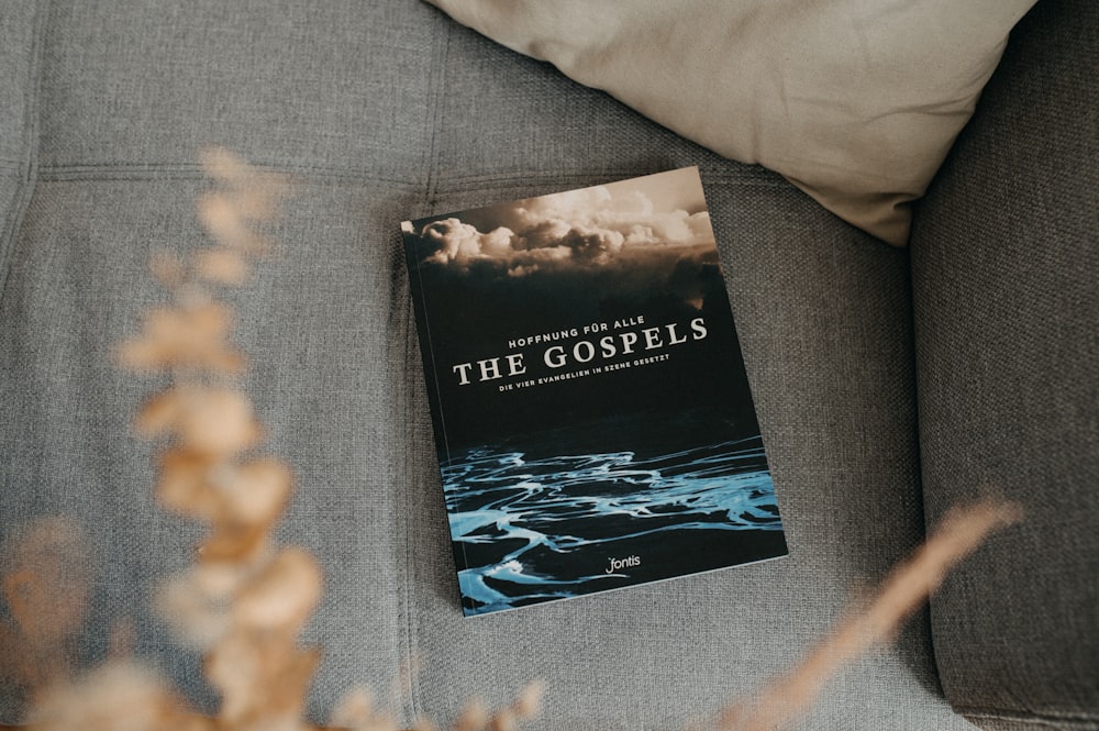 a book sitting on top of a couch next to a pillow