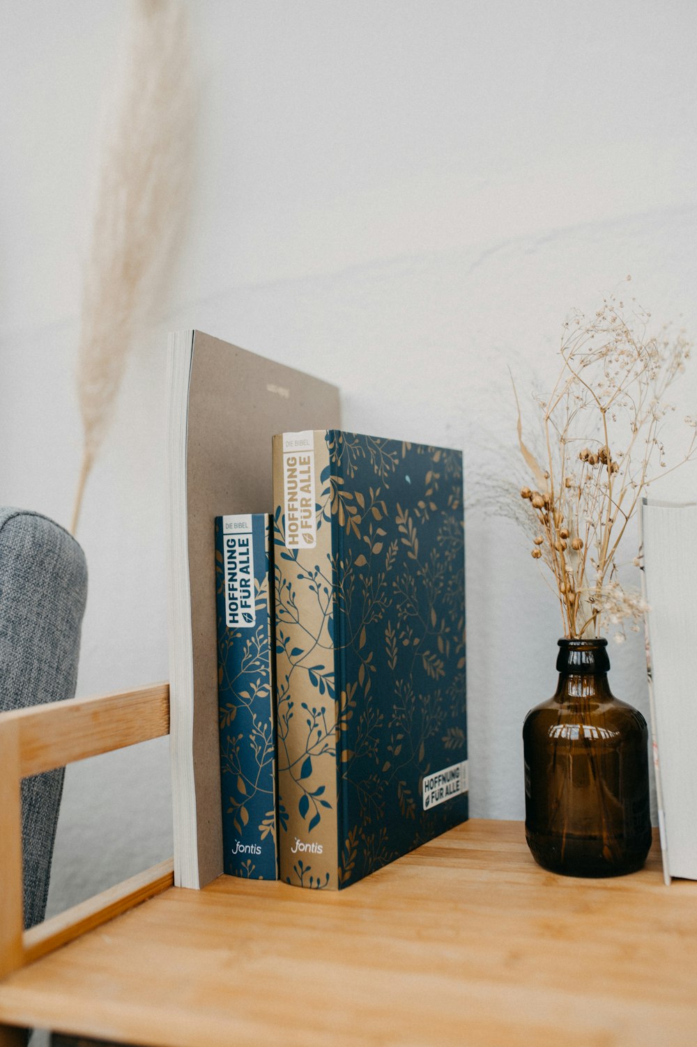 a wooden table topped with books and a vase