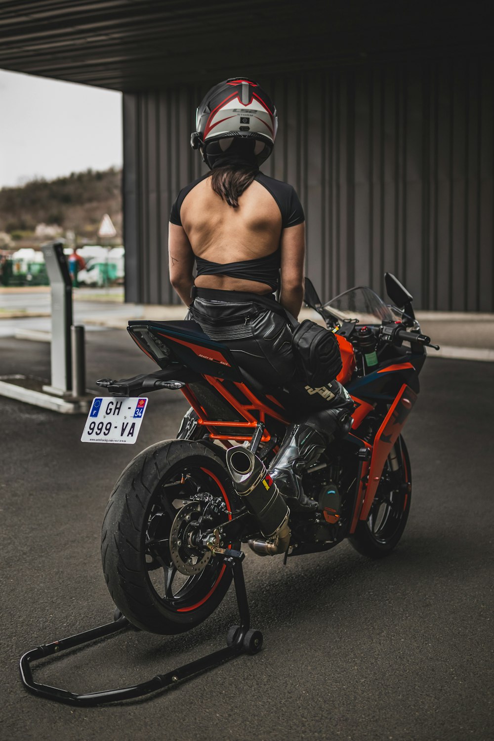 une femme portant un casque assise sur une moto