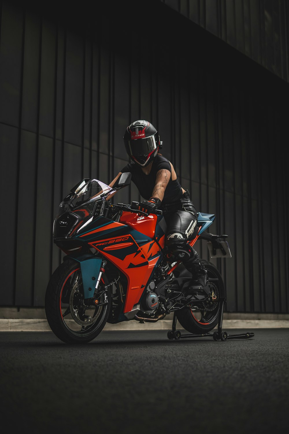 a man riding on the back of a red motorcycle